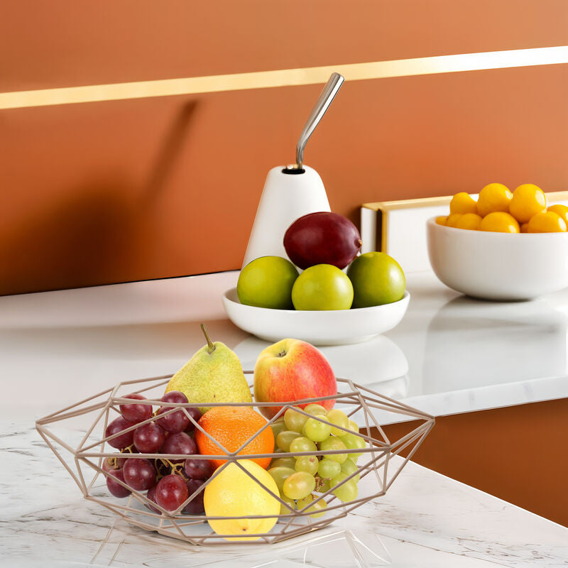 Fruit bowl with apples, pears, and grapes on a marble countertop with a brown wall background.