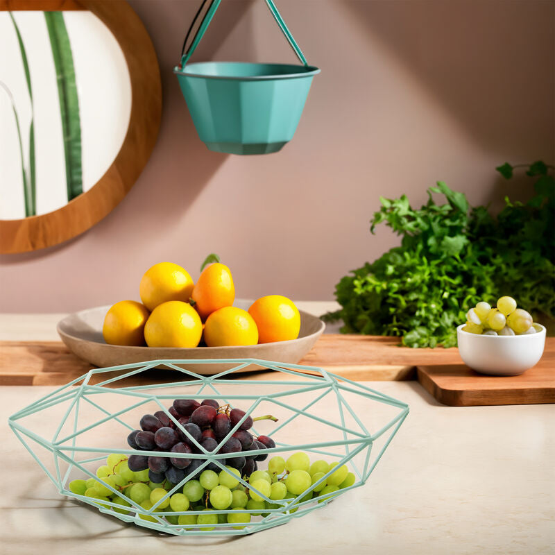 Fruit display with lemons, grapes, and oranges on a kitchen counter.