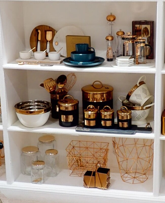 White shelving unit with decorative kitchen items including bowls, cans, and decorative objects.