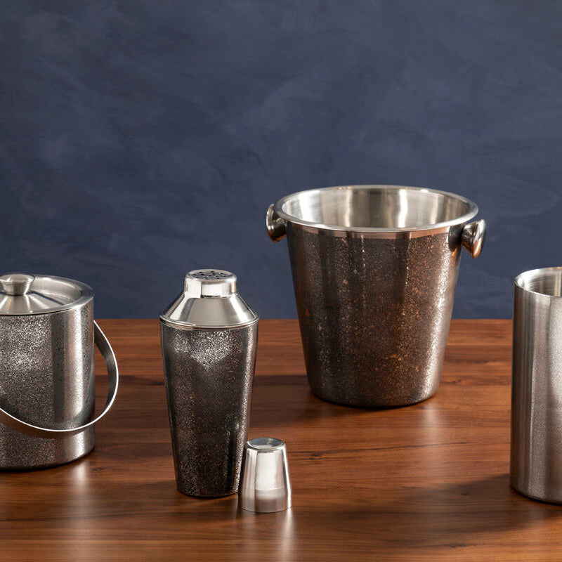 Set of silver ice buckets and shakers on a wooden surface with a dark background