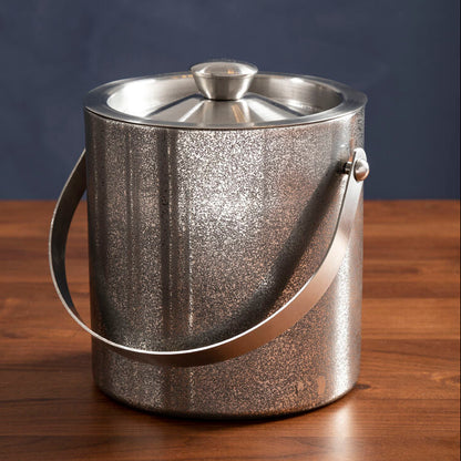 Silver ice bucket on a wooden surface with a dark blue background