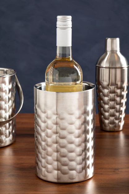 Silver textured wine cooler with a bottle of white wine on a wooden surface.