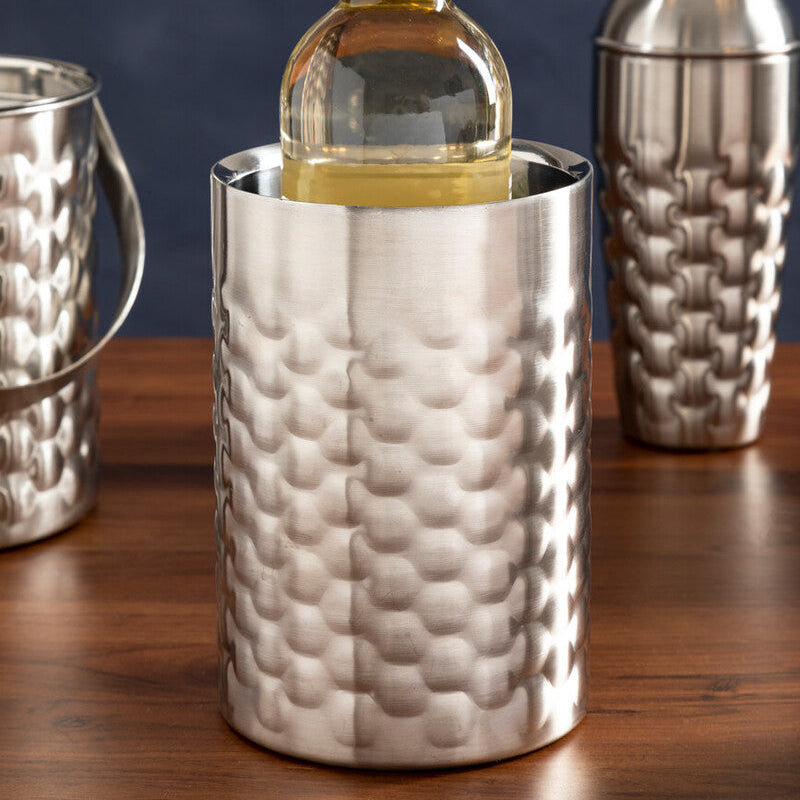 Silver textured wine cooler with a bottle of white wine on a wooden surface.