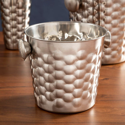 Silver textured ice buckets with a cocktail shaker on a wooden surface.