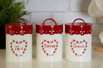 Three white canisters with red lids labeled &