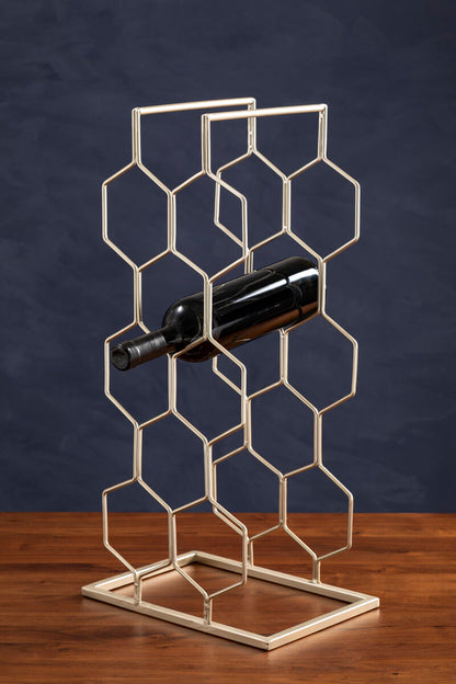 Metal wine rack with a bottle on a wooden surface against a dark background