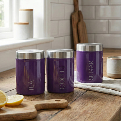 Three purple kitchen canisters labeled &