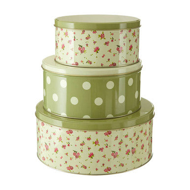 Set of three decorative tin containers with floral and polka dot patterns on a white background