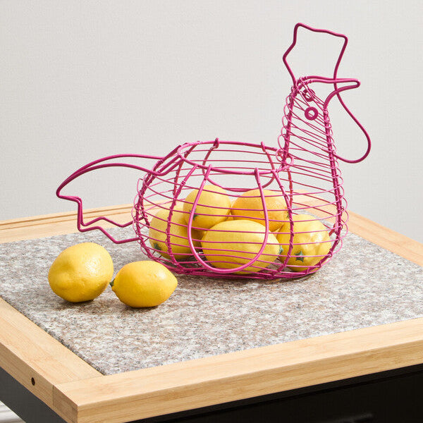 Pink wire bird-shaped basket with lemons on a wooden surface