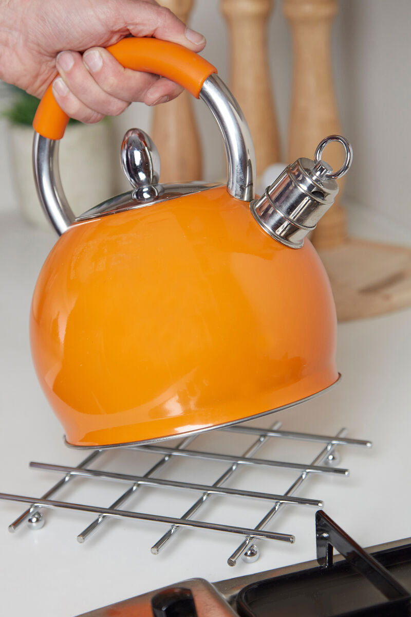Orange kettle with a silver whistle on a stove