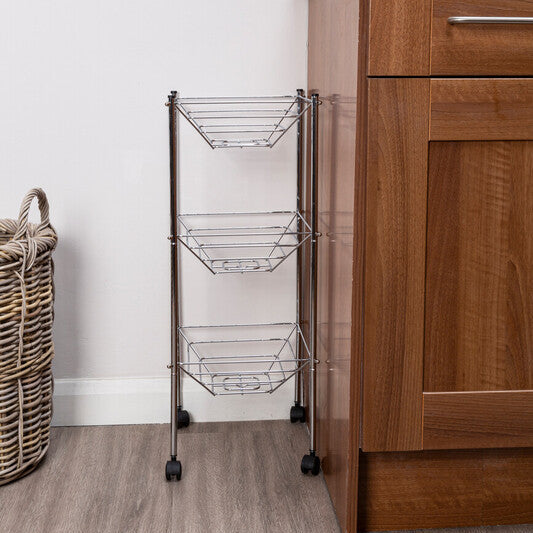 Metal storage rack with wheels next to a wooden cabinet in a kitchen setting.