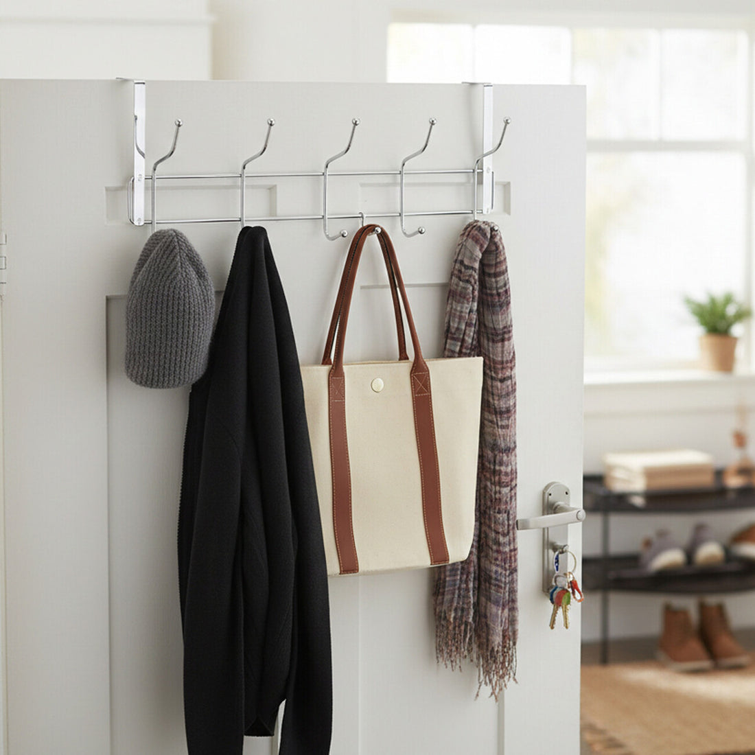 Wall-mounted hook rack with a coat, bag, and scarf on a white door.