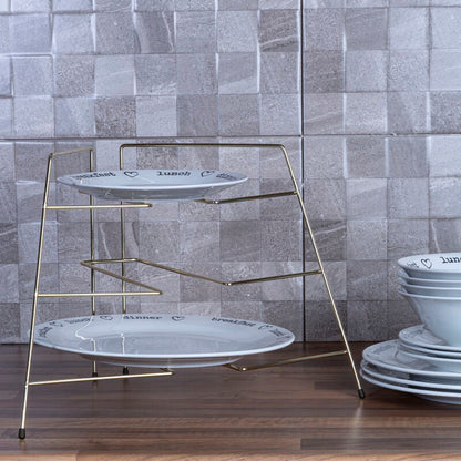 Three-tiered metal stand with white plates against a tiled wall.