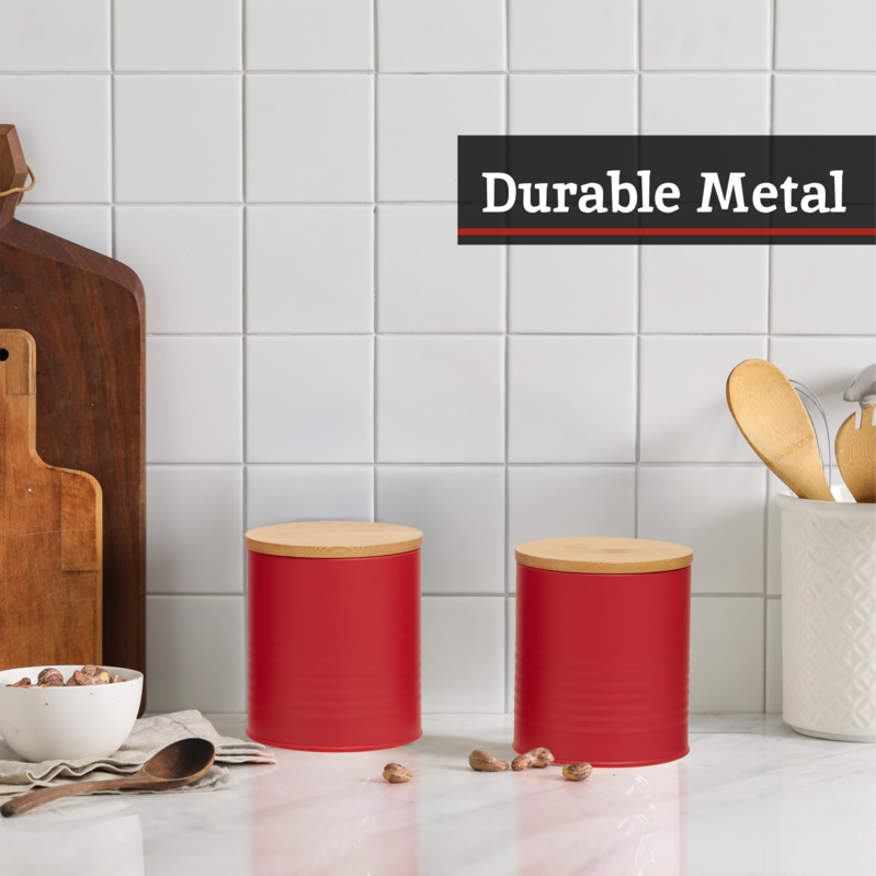 Two red canisters with wooden lids on a kitchen counter, with &