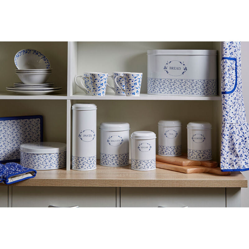 Kitchen shelves with blue and white patterned kitchenware including canisters, mugs, and a bread box.