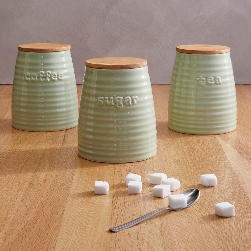 Three green ceramic canisters labeled &