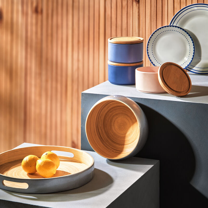 Set of ceramic bowls and plates on a modern surface with a wooden background