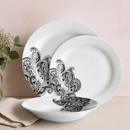 White plates with black floral patterns on a beige surface