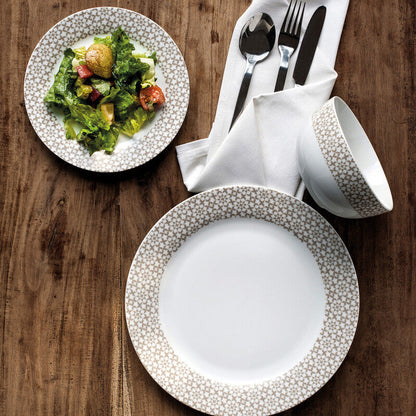 Dinnerware set with plates, cups, and cutlery on a wooden table.