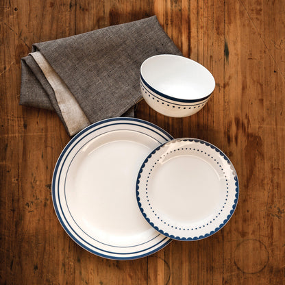 Ceramic plates and bowl with blue rim on a wooden surface