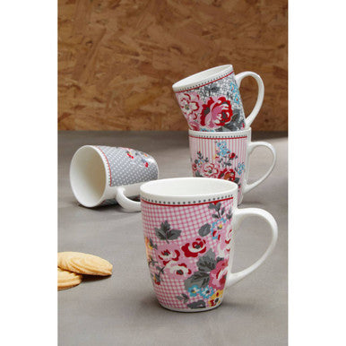 Set of floral and checkered patterned mugs on a gray surface with a wooden background.