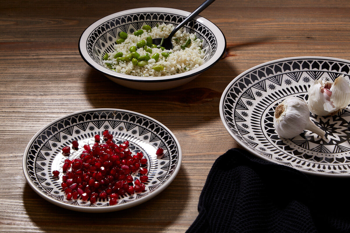 Three decorative plates with food on a wooden surface