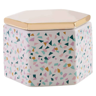 Hexagonal container with geometric pattern and gold lid on a white background