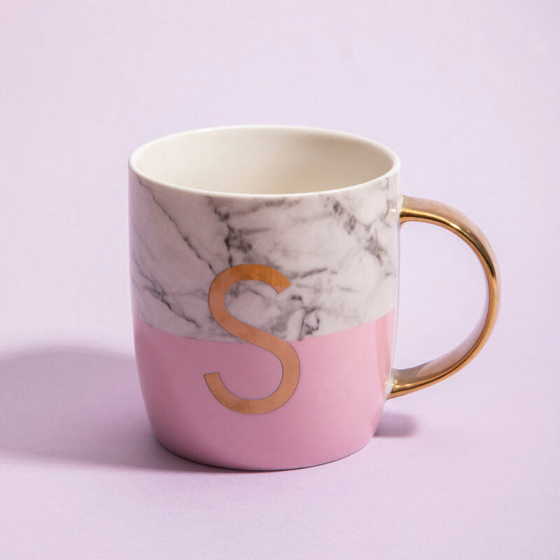 Marble-patterned mug with a pink base and gold letter &