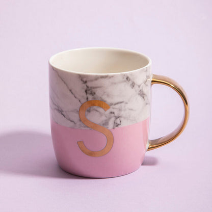 Marble-patterned mug with a pink base and gold letter &