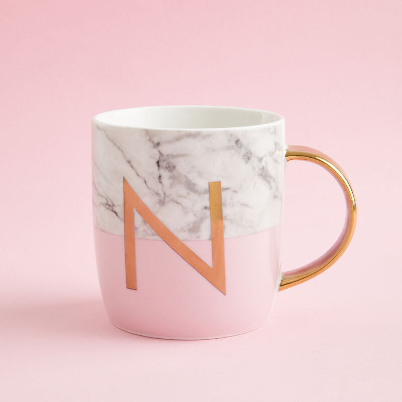 Marble-patterned mug with gold handle and letter &