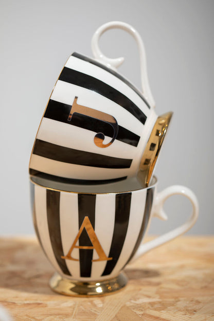 Black and white striped mug with gold letter &