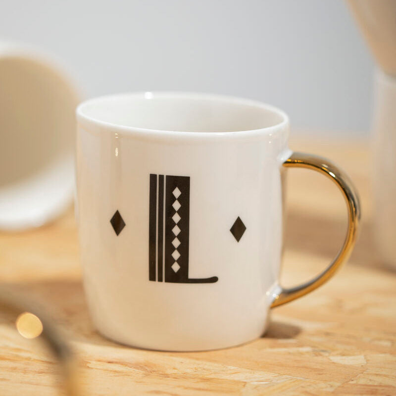 White mug with black diamond pattern on a wooden surface