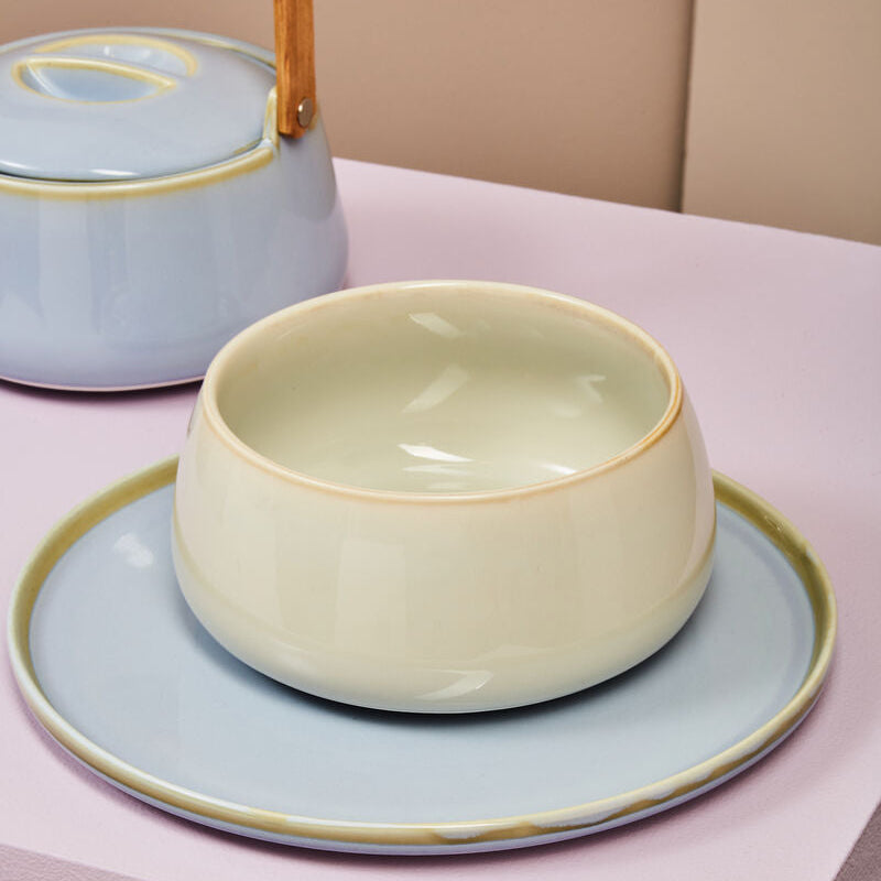 Ceramic bowl and plate set on a pastel background