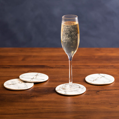 Glass of champagne on a wooden table with decorative coasters