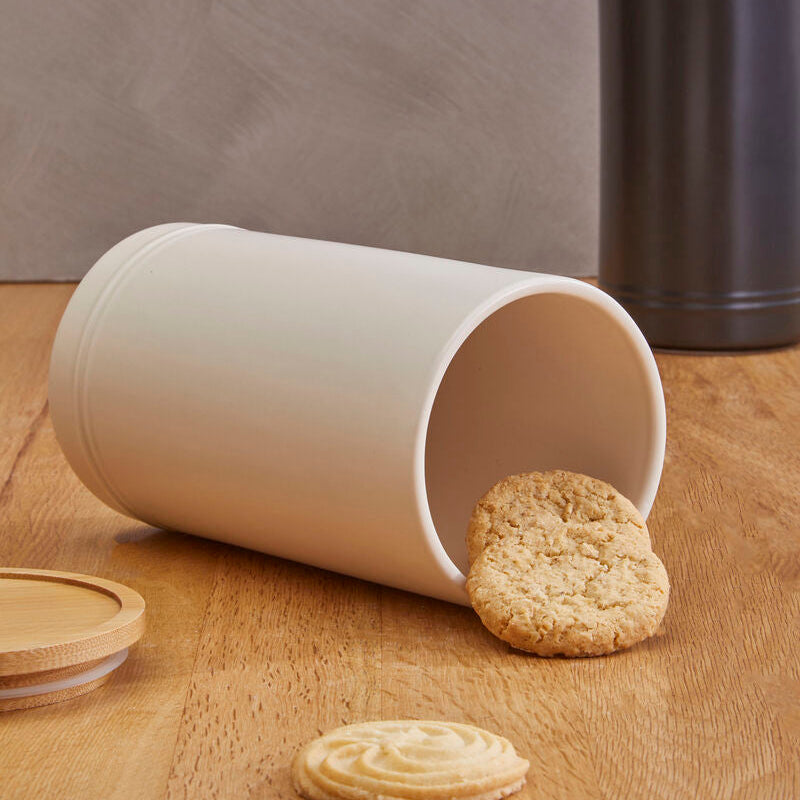 White cylindrical container with cookies on a wooden surface