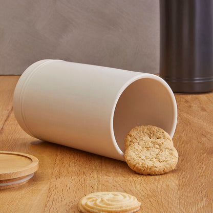 White cylindrical container with cookies on a wooden surface