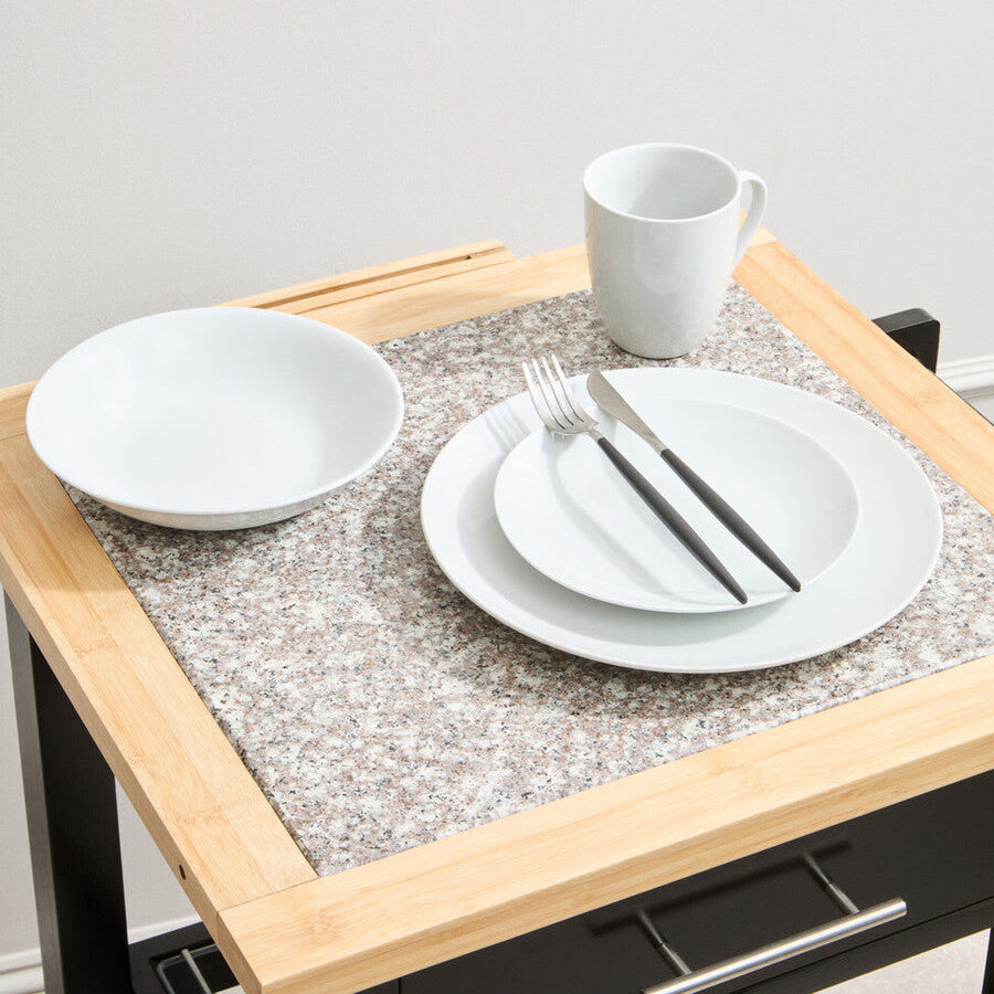 Dining table with white plates, cups, and cutlery on a gray placemat.