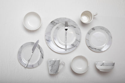 Set of marble-patterned ceramic dinnerware on a light gray background