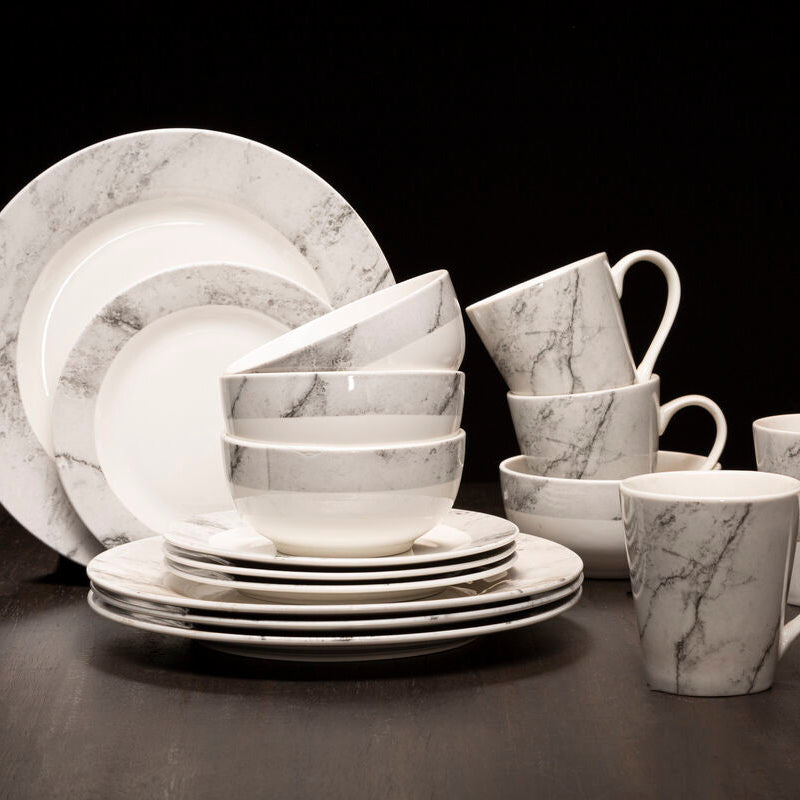 Marble-patterned ceramic dinnerware set on a dark surface with a black background
