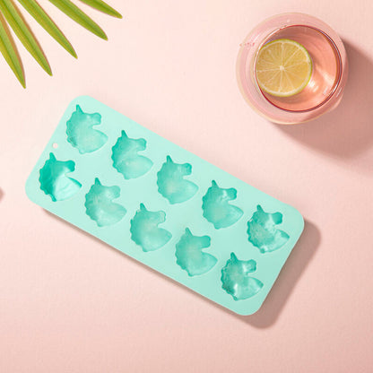 Mint green ice cube tray with animal shapes on a pink background with a glass of pink drink and lime.