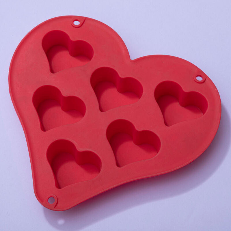 Red silicone heart-shaped mold on a light purple background