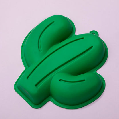 Green dollar sign-shaped mold on a light gray background