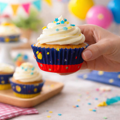Hand holding a cupcake with star-themed wrapper on a festive background