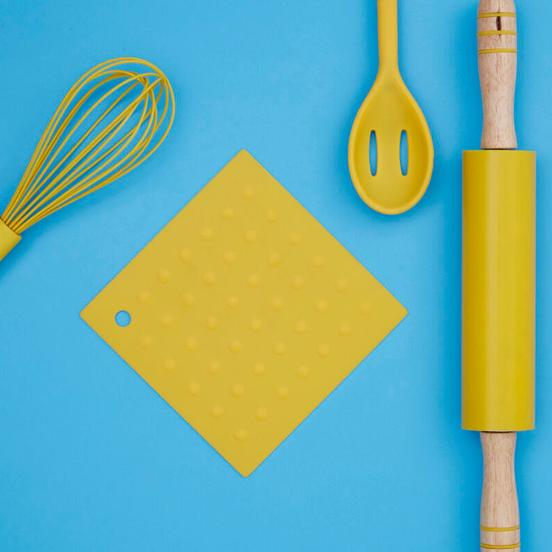 Yellow kitchen utensils including a whisk, spatula, cutting board, and rolling pin on a blue background