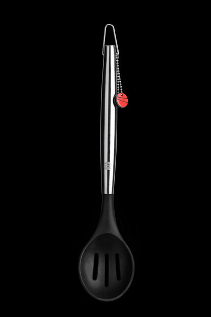 Black slotted spoon with silver handle on a black background