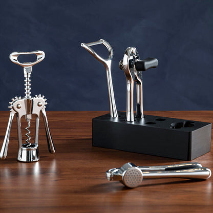 Set of corkscrew and bottle openers on a wooden surface with a dark background