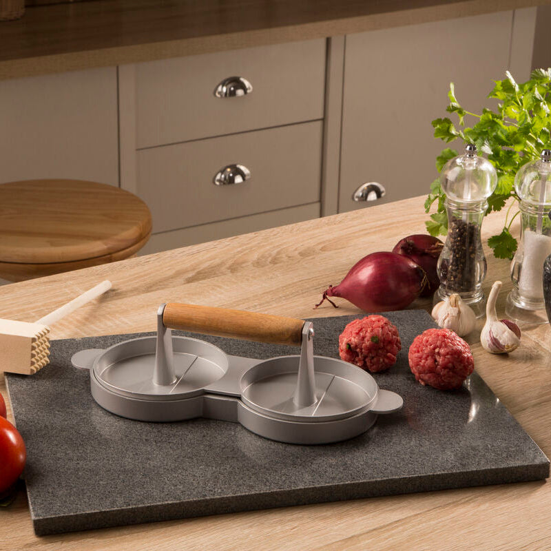 Kitchen counter with a stone cutting board, kitchen tools, and ingredients.