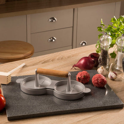 Kitchen counter with a stone cutting board, kitchen tools, and ingredients.