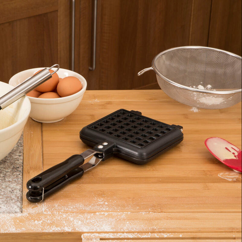 Kitchen counter with waffle maker, mixing bowl, and ingredients