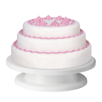 Two-tiered white cake with pink decorations on a white stand against a white background